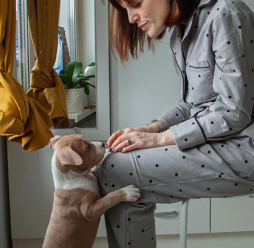 lady playing with her puppy at home