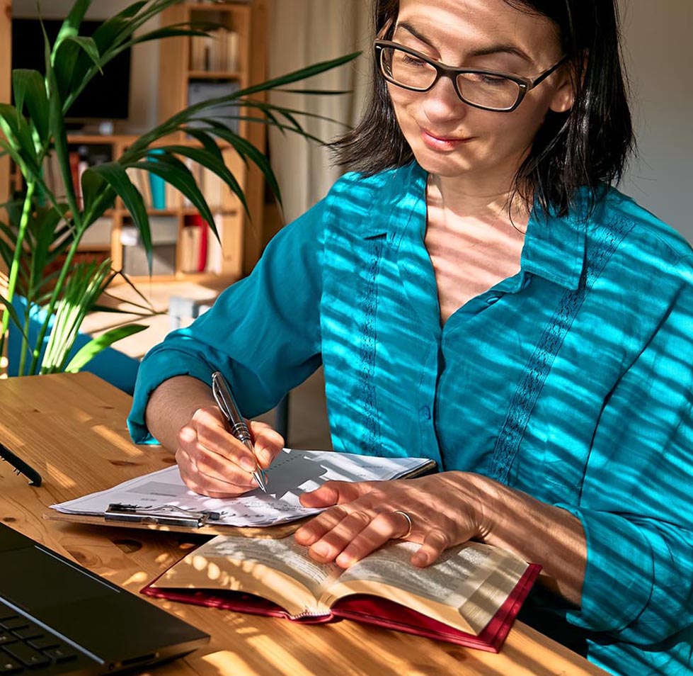 woman sitting by window in front of laptop